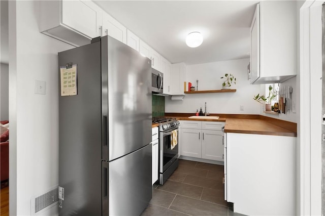 5129 Caste Dr, Whitehall, PA 15236 - kitchen featuring appliances with stainless steel finishes, a sink, open shelves, and white cabinets