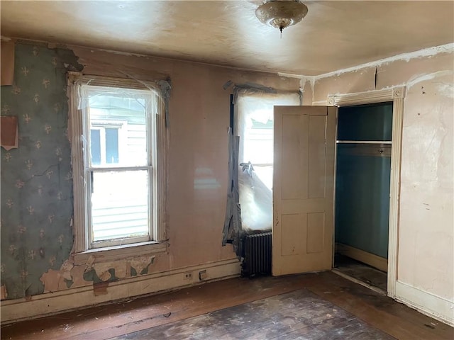 230 E 15th Ave, Homestead, PA 15120 - unfurnished bedroom with radiator heating unit, hardwood / wood-style flooring, and a closet