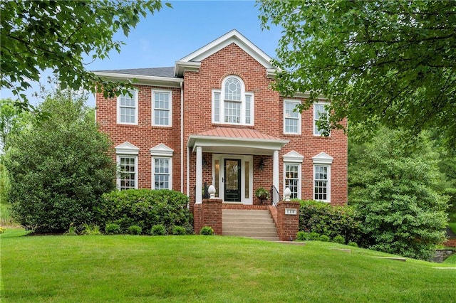 colonial home featuring a front lawn and brick siding