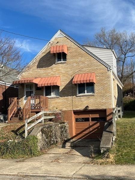 view of front of home featuring brick siding and concrete driveway