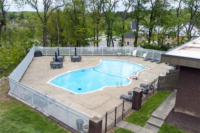 community pool featuring fence and a patio