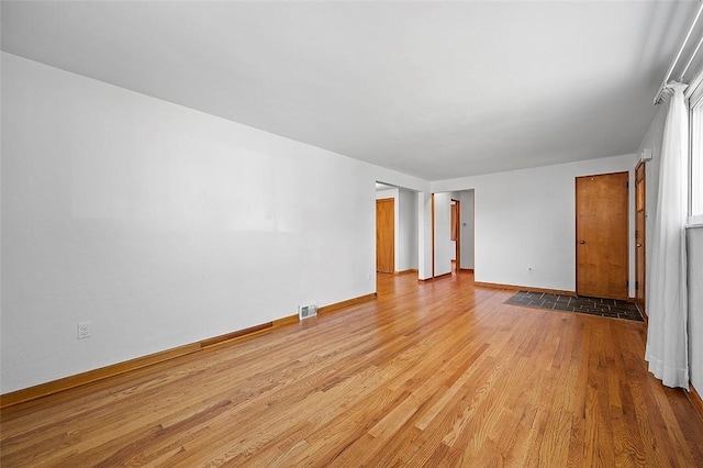 empty room featuring wood finished floors and baseboards