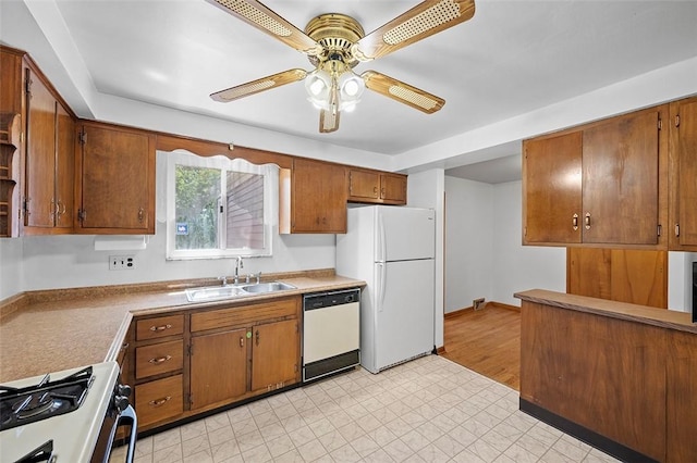 kitchen featuring a sink, white appliances, ceiling fan, and brown cabinetry