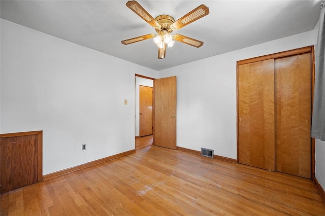 unfurnished bedroom featuring light wood-style floors, baseboards, ceiling fan, and a closet