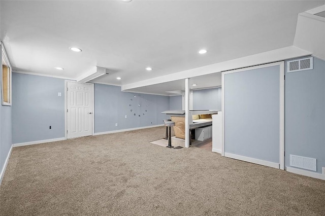 finished below grade area with carpet flooring, baseboards, recessed lighting, and ornamental molding