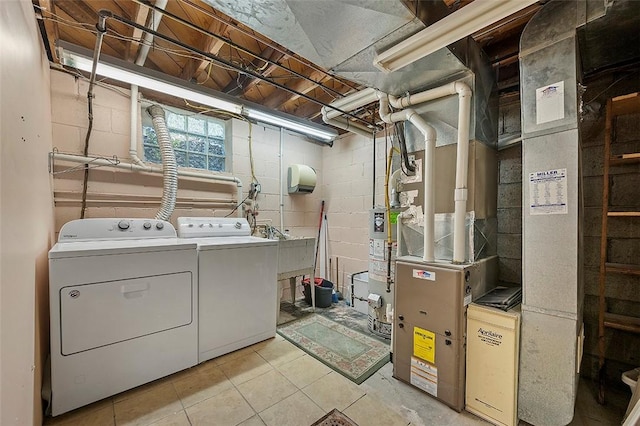 laundry room with washer and dryer, gas water heater, and light tile patterned floors