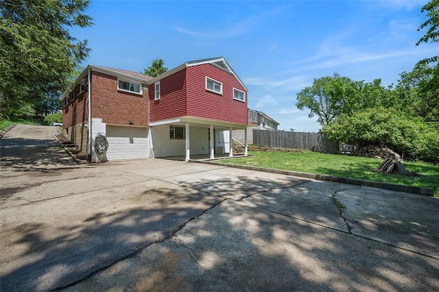 view of side of property featuring a garage, driveway, and brick siding