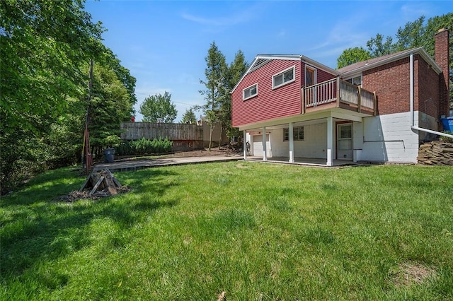 back of property featuring an attached garage, a deck, and a chimney