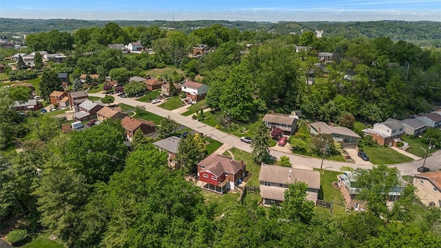 view of property location with nearby suburban area and a forest