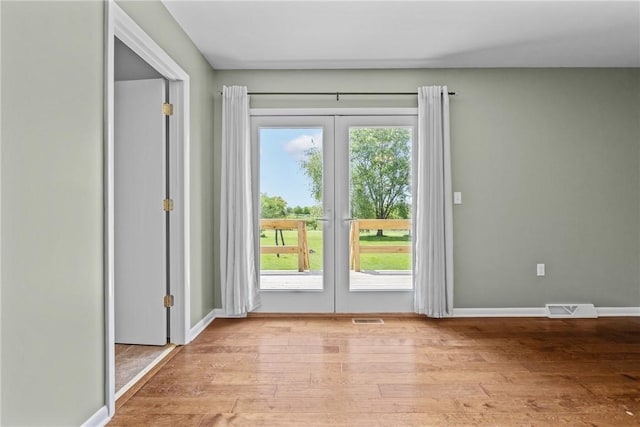 entryway featuring french doors, wood finished floors, and baseboards