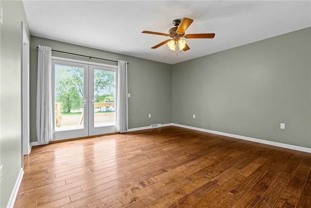 spare room featuring hardwood / wood-style floors, ceiling fan, and baseboards