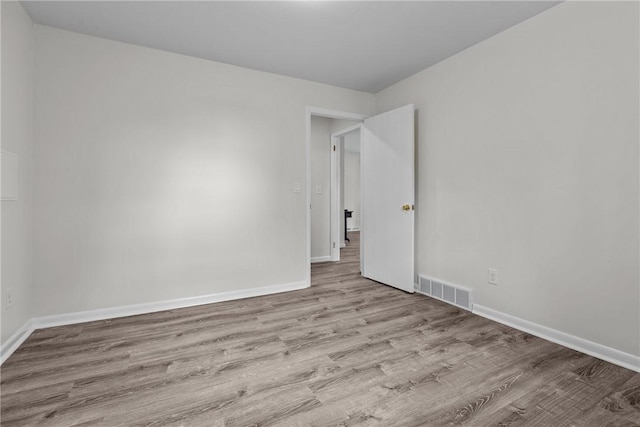 spare room featuring wood finished floors and baseboards