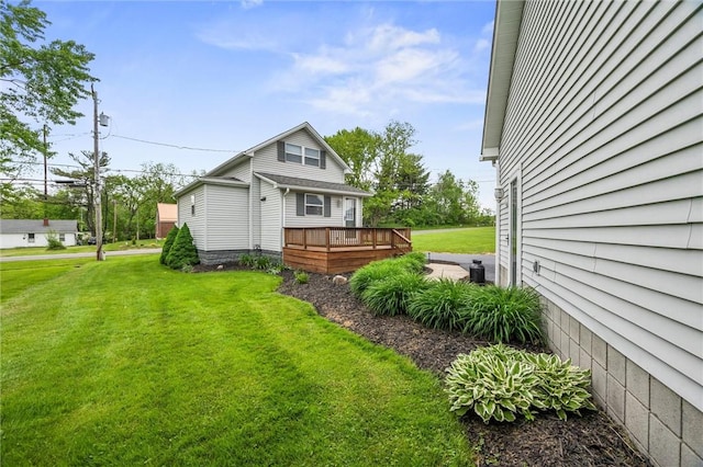 view of side of home with a wooden deck and a lawn