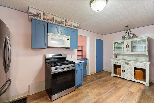 816 E 11th Ave, Munhall, PA 15120 - kitchen with appliances with stainless steel finishes, blue cabinetry, light wood finished floors, and light countertops