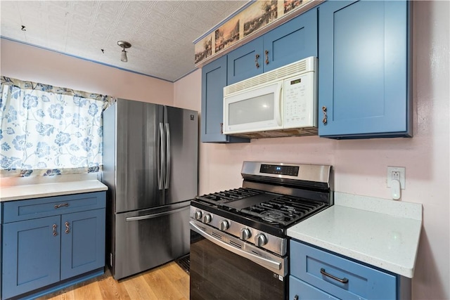 816 E 11th Ave, Munhall, PA 15120 - kitchen featuring stainless steel appliances, blue cabinetry, light countertops, and an ornate ceiling