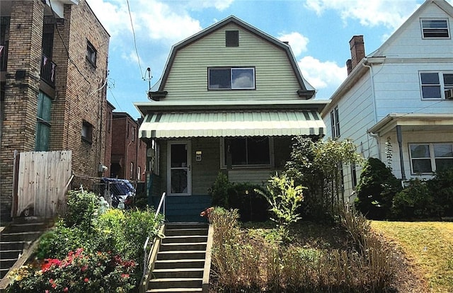 816 E 11th Ave, Munhall, PA 15120 - colonial inspired home featuring a gambrel roof, stairway, and covered porch