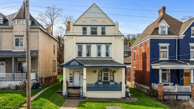 victorian home with a porch, stucco siding, and a front lawn