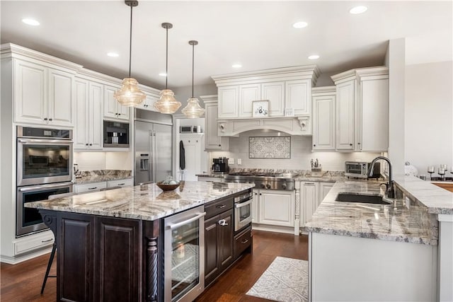 347 Buckingham Dr, Peters Twp, PA 15367 - kitchen with beverage cooler, stainless steel appliances, a sink, a breakfast bar area, and light stone countertops