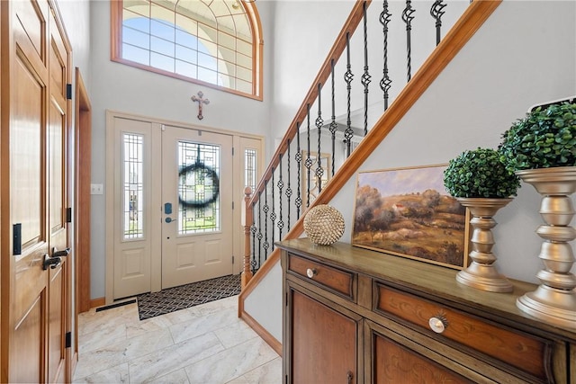 entryway with stairs and a high ceiling