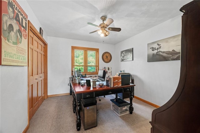 office featuring a ceiling fan, baseboards, and carpet flooring