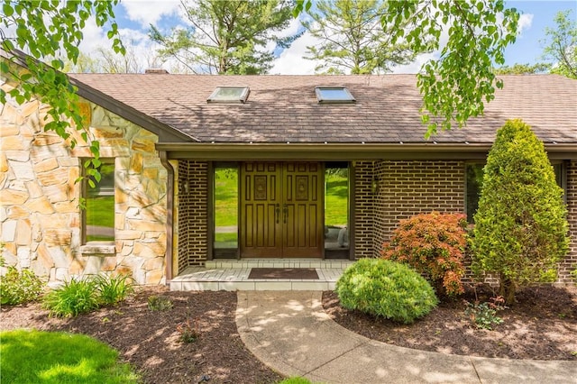 114 Moore Dr, Peters Twp, PA 15317 - view of exterior entry with a shingled roof, stone siding, and brick siding
