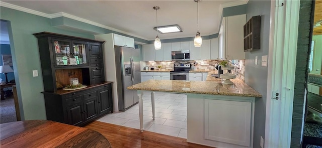 532 Strope Rd, Pa, PA 15021 - kitchen with stainless steel appliances, tasteful backsplash, ornamental molding, light stone countertops, and a peninsula