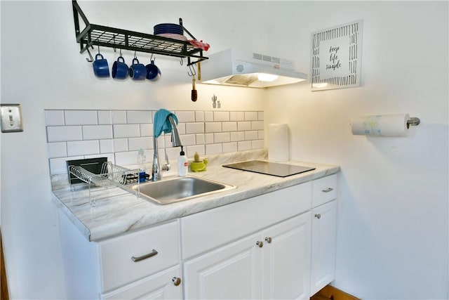 375 Main St, Volant Boro, PA 16156 - kitchen with under cabinet range hood, black electric cooktop, a sink, backsplash, and light countertops
