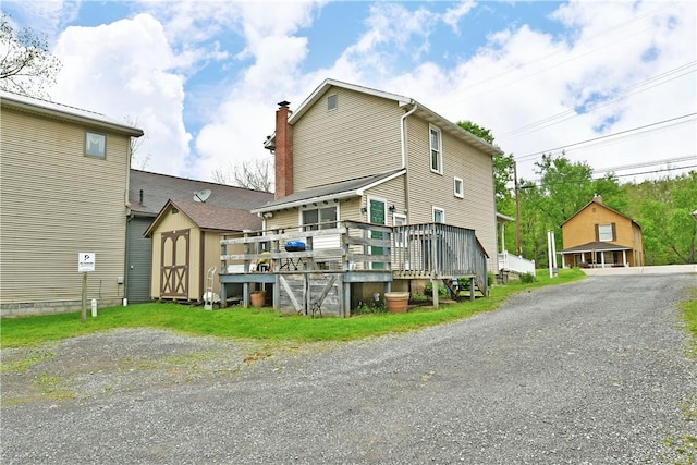 375 Main St, Volant Boro, PA 16156 - back of house featuring a storage unit, a deck, an outbuilding, and a chimney