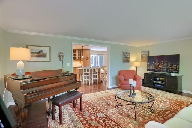 living room featuring ornamental molding, baseboards, and wood finished floors