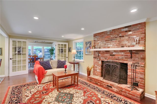 living room with crown molding, baseboards, wood finished floors, recessed lighting, and a fireplace