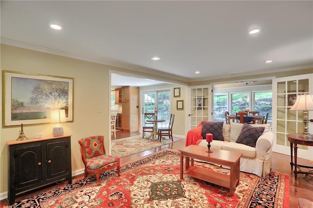 living area featuring ornamental molding, wood finished floors, recessed lighting, baseboards, and plenty of natural light