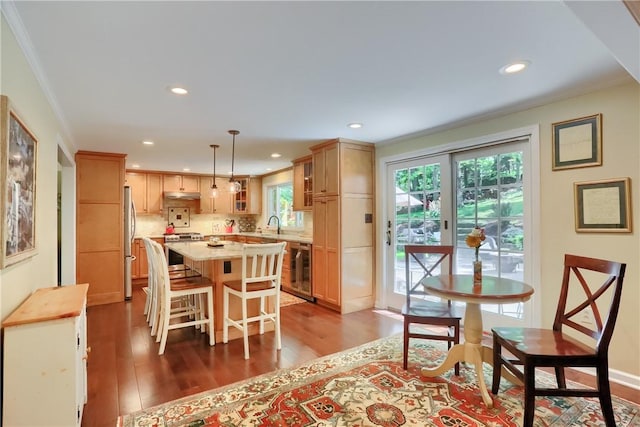 dining space featuring dark wood finished floors, recessed lighting, beverage cooler, and crown molding