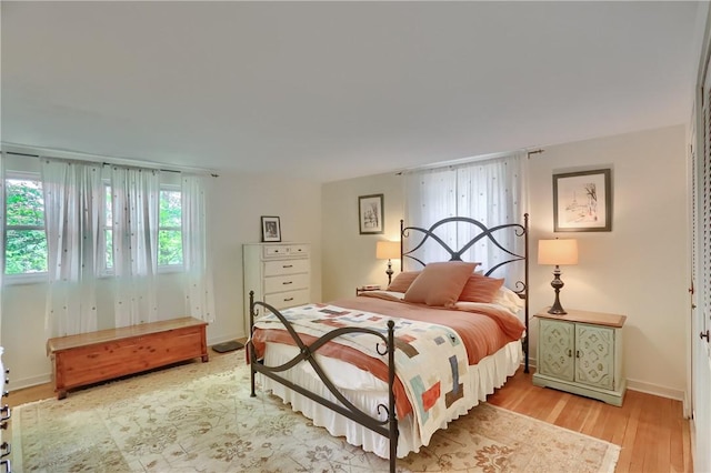 bedroom with light wood-style flooring and baseboards