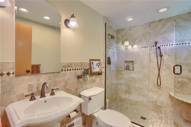 full bath with a sink, a shower stall, toilet, wainscoting, and recessed lighting