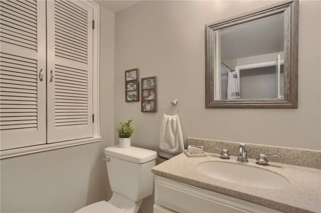 bathroom with toilet, vanity, and curtained shower