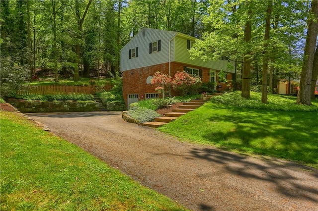 view of front facade with stairway, an attached garage, driveway, brick siding, and a front yard
