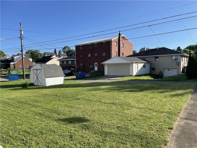 view of green lawn with a storage unit, an outbuilding, and a garage