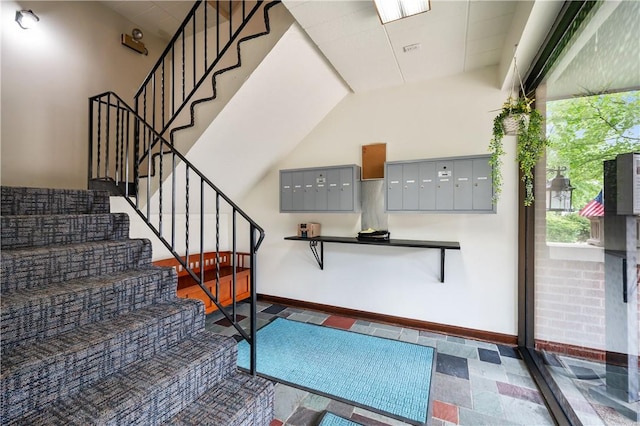 stairway featuring mail area and baseboards