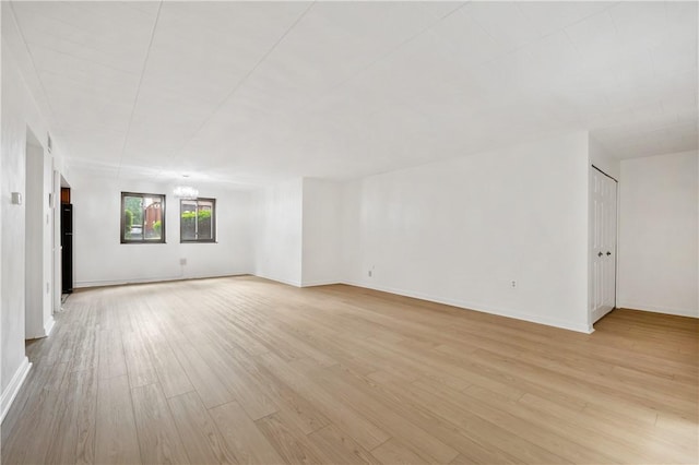 unfurnished room with light wood finished floors and baseboards