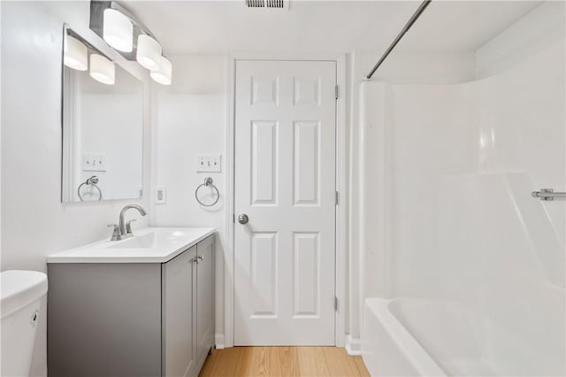 full bath featuring vanity, wood finished floors, and toilet
