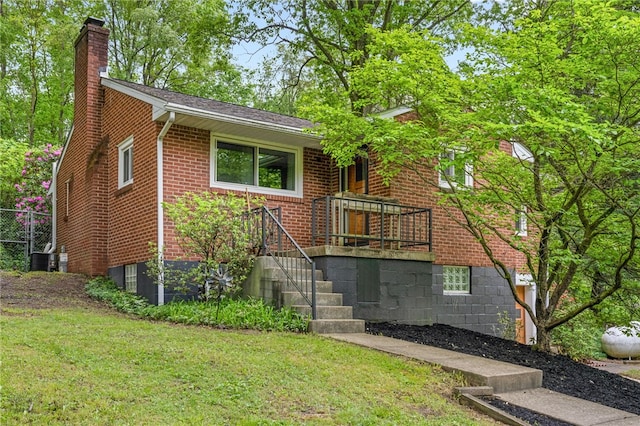 318 Milbren Dr, Penn Hills, PA 15147 - view of front of house featuring a chimney, brick siding, a front yard, and central AC