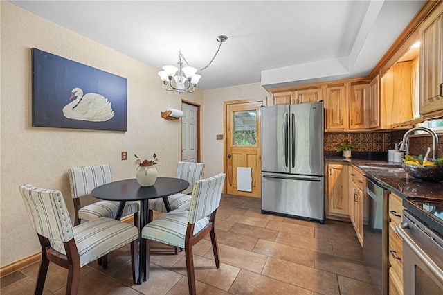 318 Milbren Dr, Penn Hills, PA 15147 - kitchen featuring stainless steel appliances, a chandelier, tasteful backsplash, a sink, and baseboards