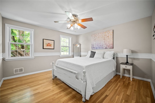 bedroom featuring multiple windows, wood finished floors, and baseboards