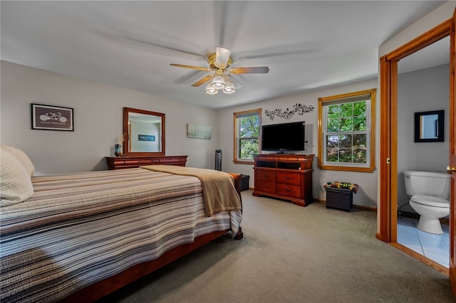 carpeted bedroom with ceiling fan and baseboards