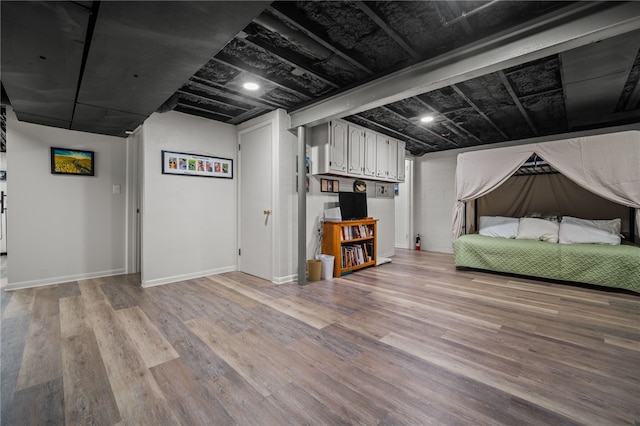 below grade area with light wood-style floors and baseboards