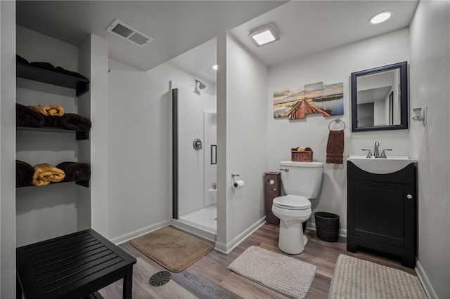 full bath with wood finished floors, a shower stall, toilet, baseboards, and vanity