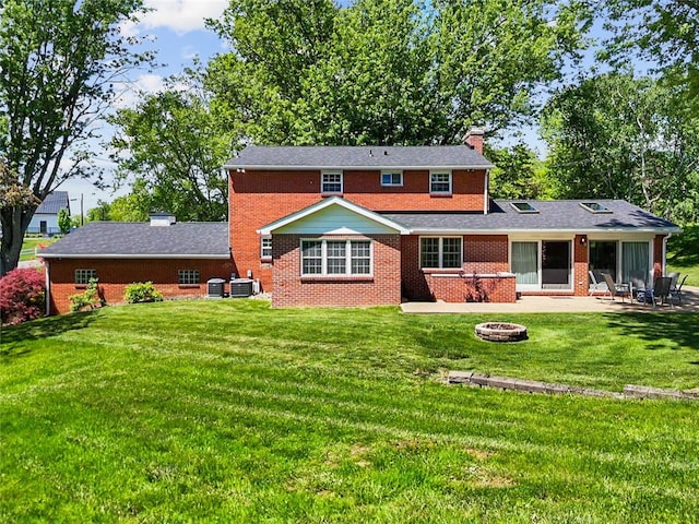 rear view of house featuring an outdoor fire pit, a chimney, a patio, and a lawn