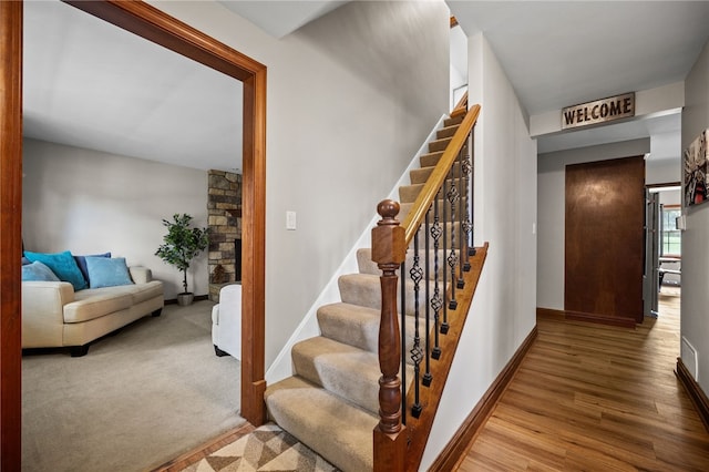 stairway with wood finished floors and baseboards