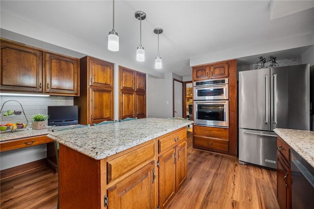 kitchen featuring appliances with stainless steel finishes, dark wood-type flooring, hanging light fixtures, and decorative backsplash