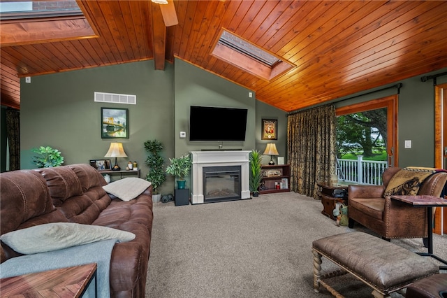 living room with a skylight, carpet, wood ceiling, a glass covered fireplace, and vaulted ceiling